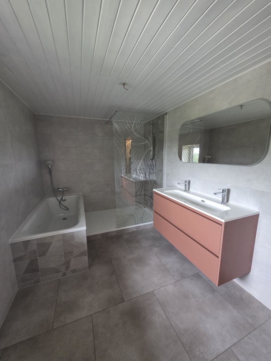 Salle de bain avec meuble double vasque rose, baignoire et douche à paroi décorée
